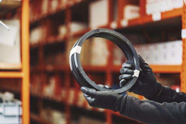 Operario sosteniendo un retén de gran diámetro con guantes de trabajo