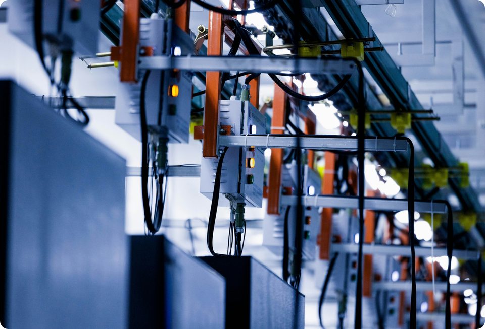 Línea de montaje industrial con cuadros de control y transportadores aéreos